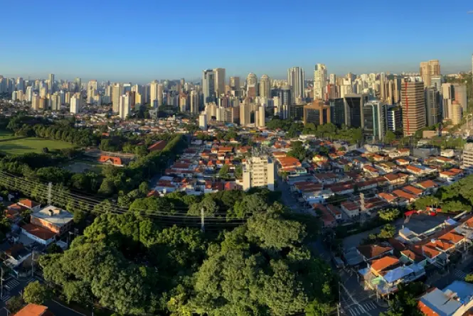 Imagem aérea de cidade com diversas árvores e prédios ao fundo