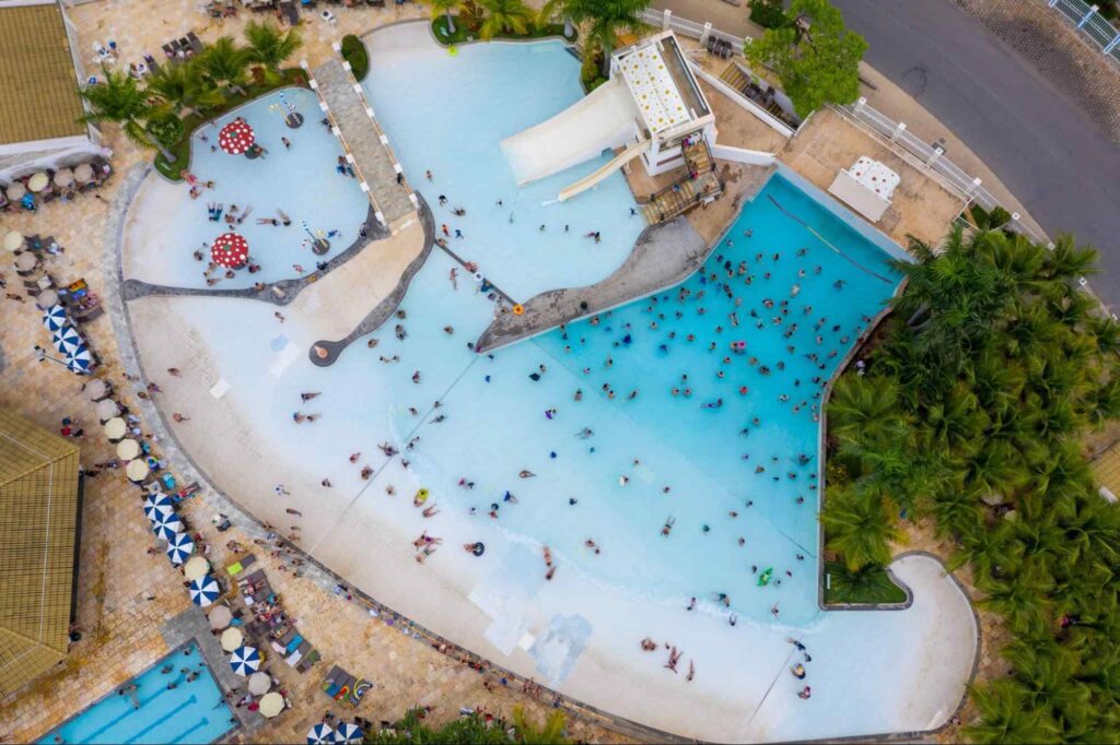 Imagem aérea de uma das piscinas no complexo Water Park em Caldas Novas. Várias pessoas estão na água e sentadas nas cadeiras de sol.