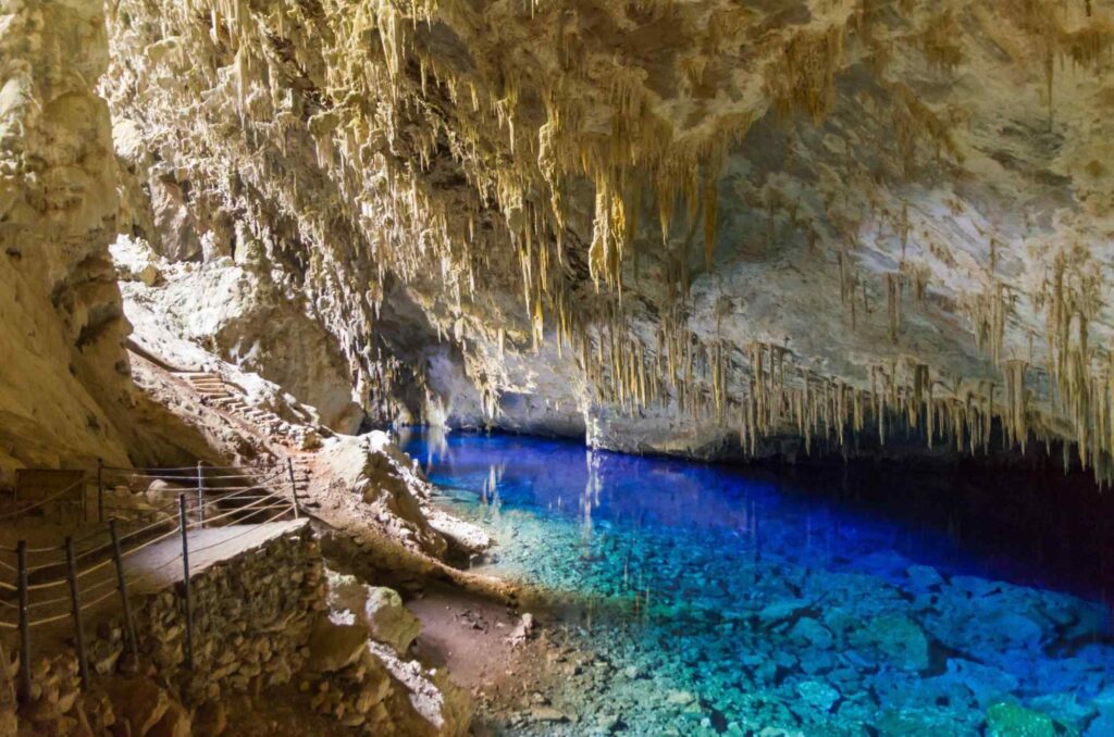 Interior da Gruta do Lago Azul em Bonito, Mato Grosso do Sul. A água azul cristalina faz contraste com as paredes de pedra branca e amarelada