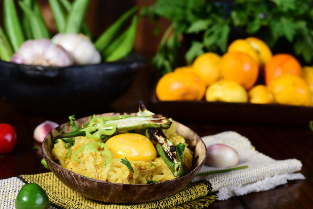 Prato de arroz com pequi em uma mesa enfeitada com outras frutas típicas